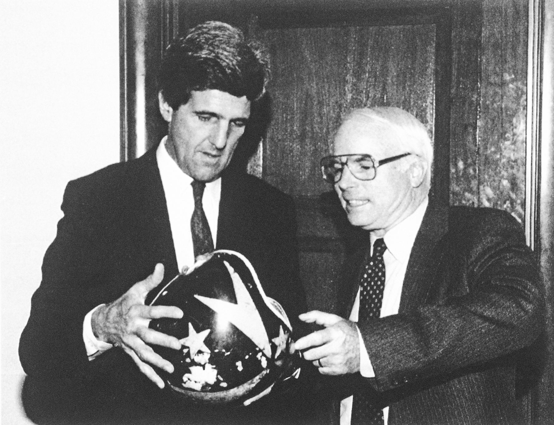 Sen. John Kerry gives Sen. John McCain his pilot's helmet on Capitol Hill in Washington, Dec. 2, 1992.