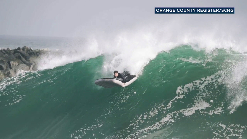 Surfer uses inflatable mattress as board as he catches waves in OC