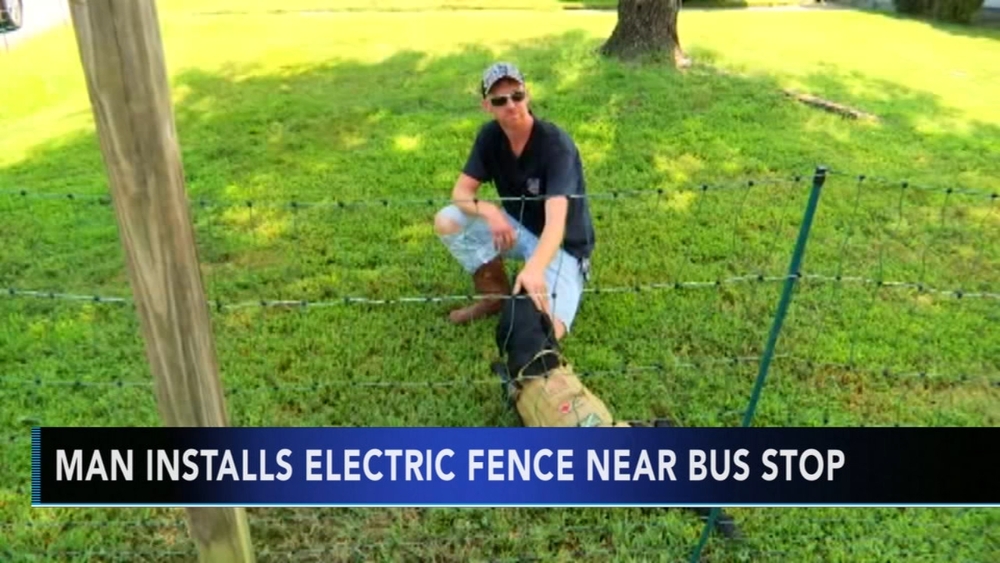 Man installs electric fence near bus stop