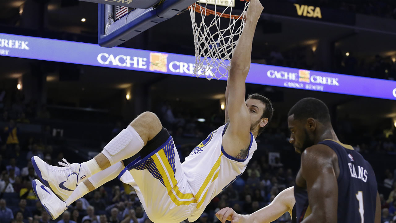 Golden State Warriors' Andrew Bogut hangs on the rim