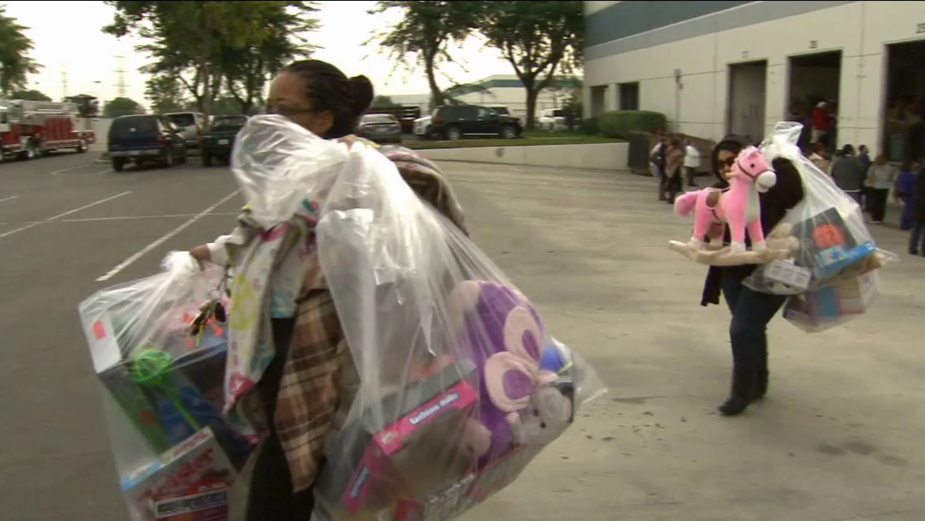 Two women walk away with toys donated to ABC7's Spark of Love toy drive on Saturday, Dec. 20, 2014.