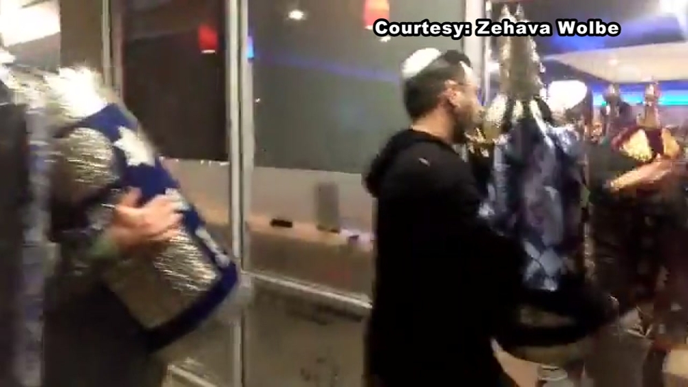 Congregants sing as Torahs removed