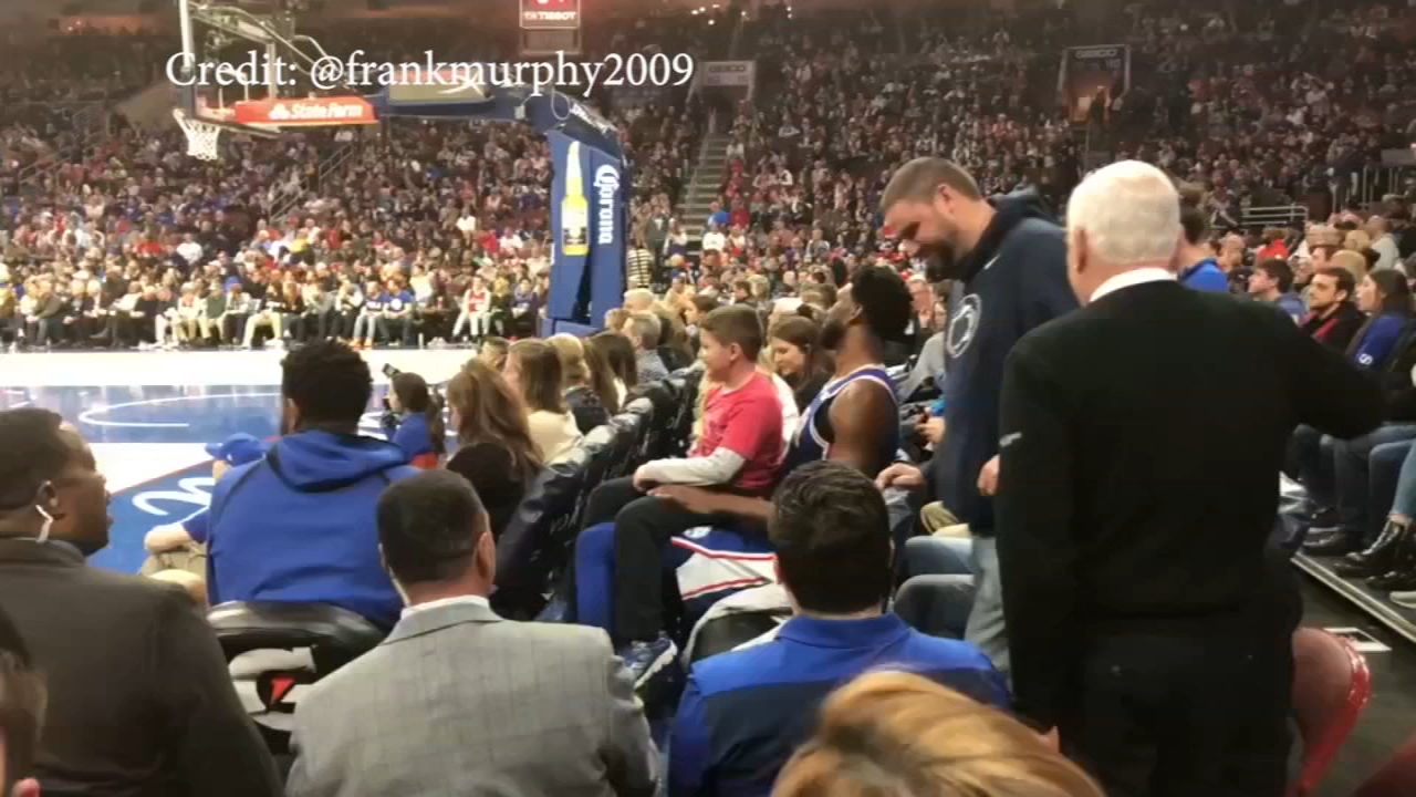 Joel Embiid sits with young fan during game