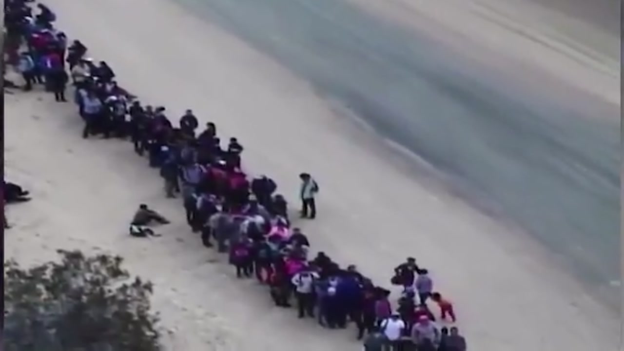 Video shows group of 376 migrants who entered the US in an area already protected by a fence.