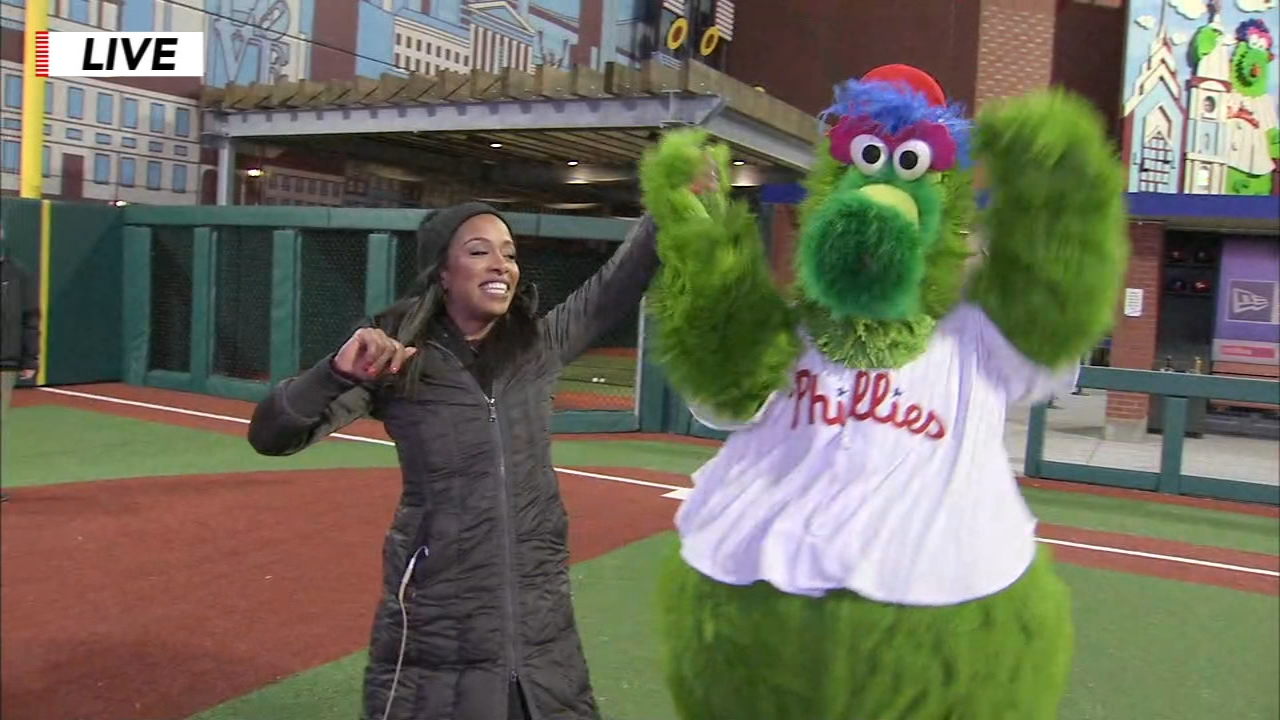 Jeannette Reyes scores a hit off the Phillie Phanatic