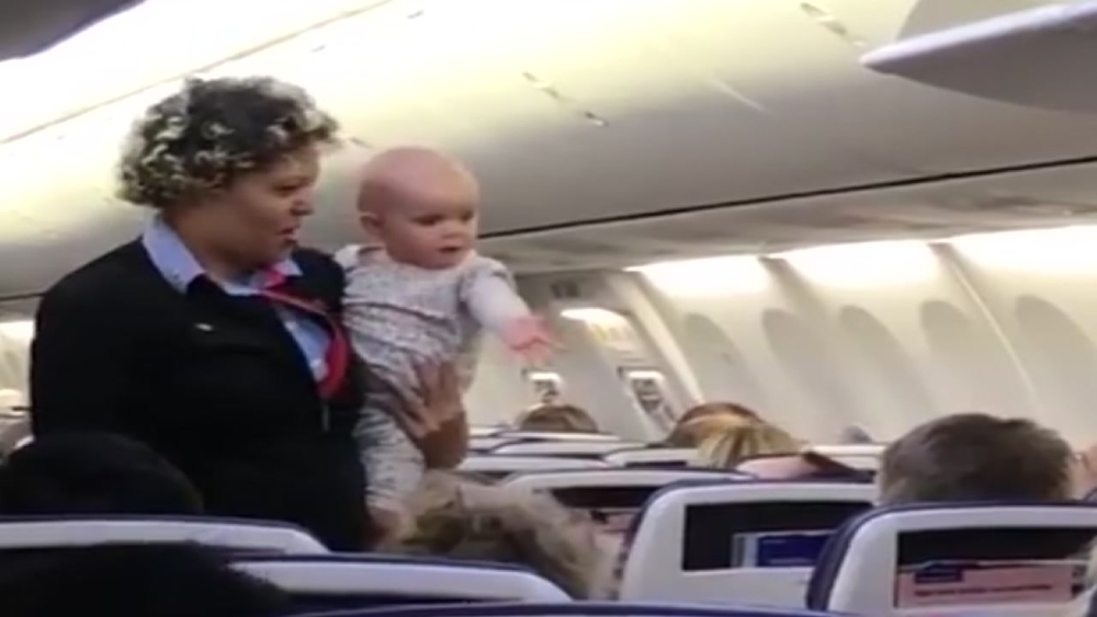 Flight attendant introduces infant passenger to other travelers