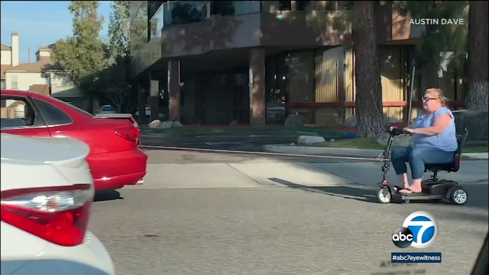 Woman on motorized scooter pulled by car on Santa Clarita street