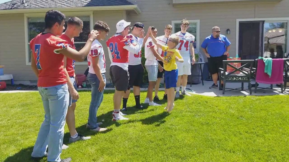Football players surprise young birthday boy with autism
