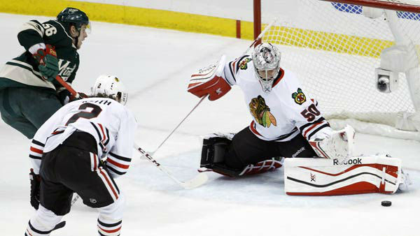 Chicago Blackhawks goalie Corey Crawford (50) deflects a shot by Minnesota Wild left wing Erik Haula.