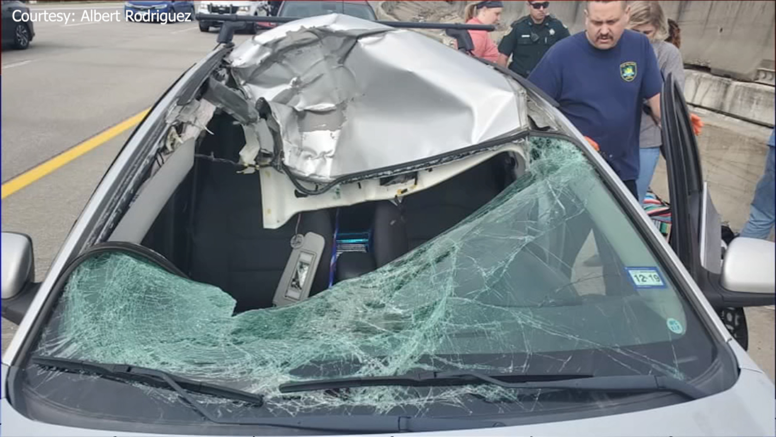 Woman walks away uninjured after tire crashes into her windshield in
