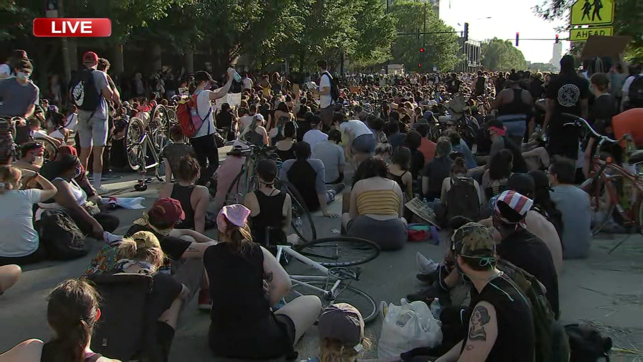 Chicago protestors sit down in middle of Division Street