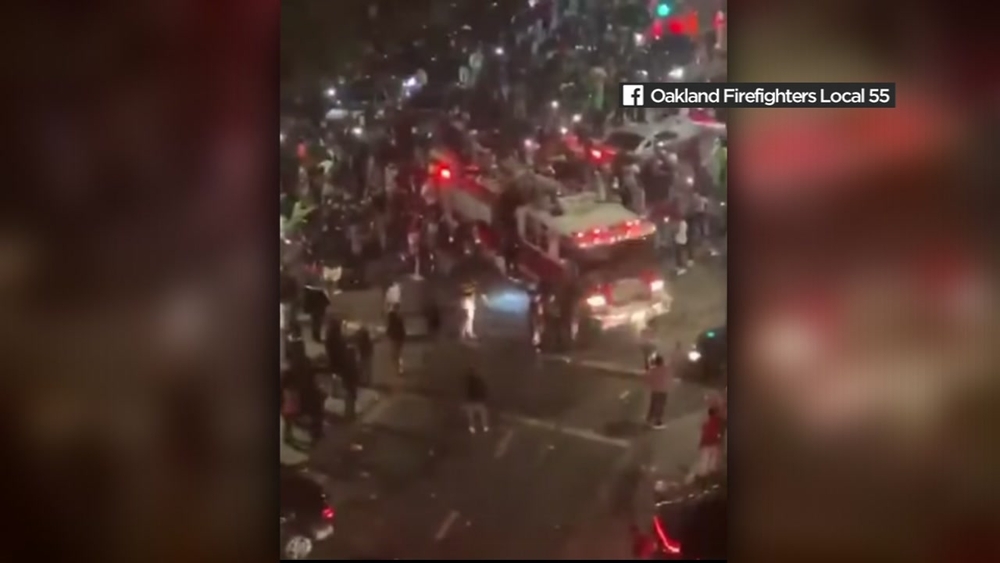 VIDEO: Crowds block, climb on Oakland fire truck on its way to 911 call