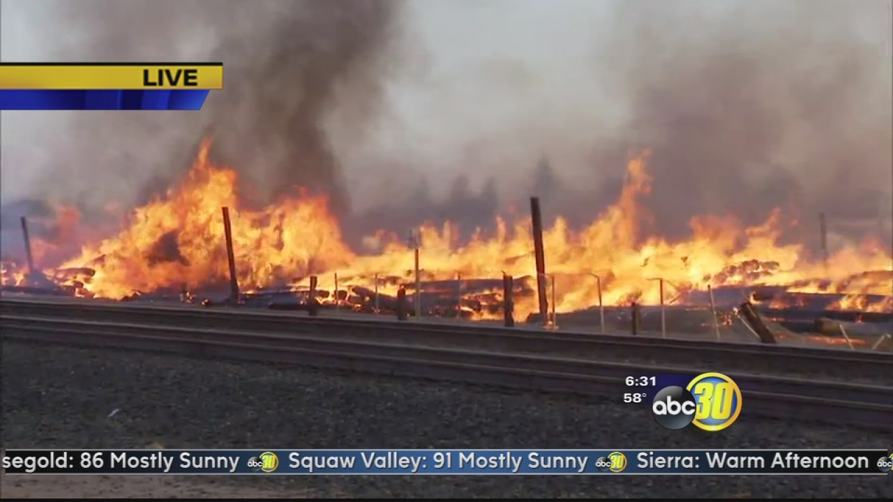 Large fire at utility yard burning pile of power poles