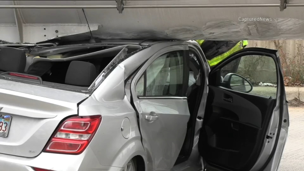 Car is dragged by semi-truck after woman runs red light