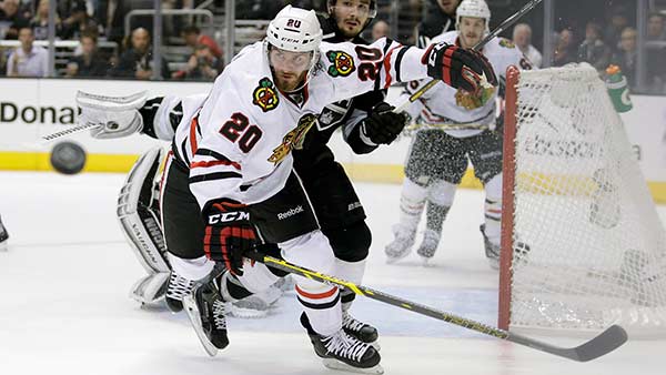 Chicago Blackhawks left wing Brandon Saad, left, and Los Angeles Kings defenseman Slava Voynov go after the puck during the first period of Game 4.