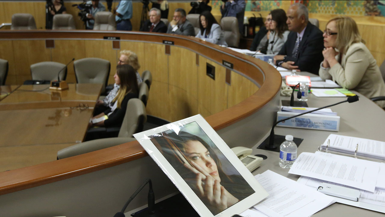 Photo of Brittany Maynard sits on dias as members of the Senate Health Committee listen to testimony on proposed legislation allowing doctors to prescribe life ending medication