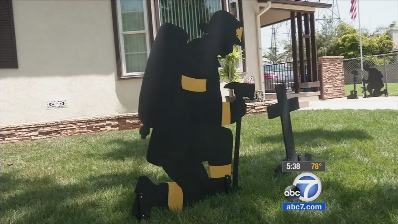 A silhouette of a firefighter, meant as a tribute piece, is put on display on James Krupa's yard.