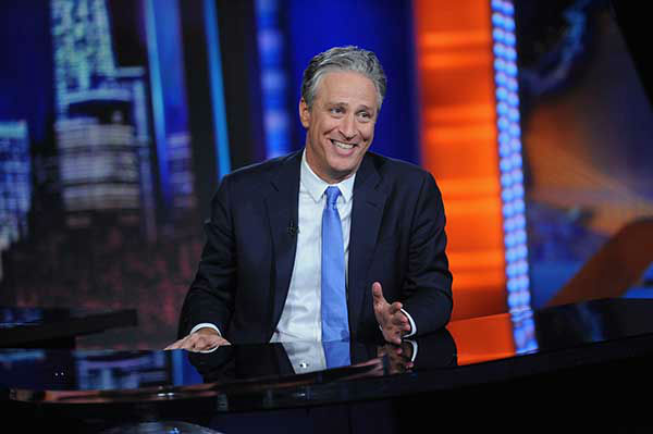 Stewart sits at the hosting desk during his final episode