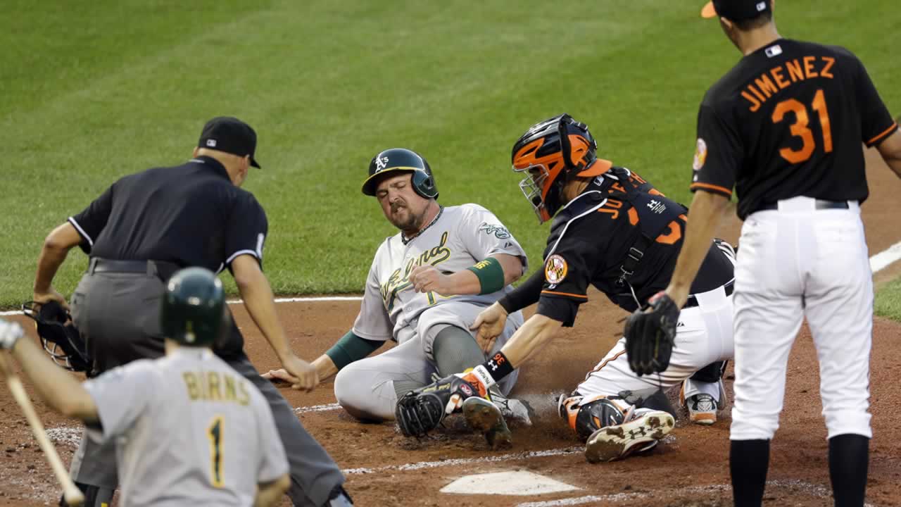 Orioles catcher Caleb Joseph tags out Athletics' Billy Butler on a single by Marcus Semien during the second inning of a baseball game, Friday, Aug. 14, 2015, in Baltimore. 