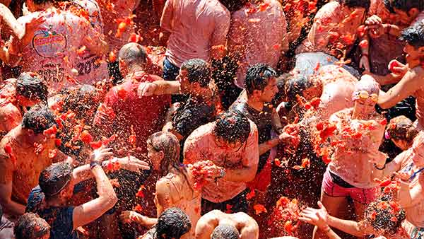 Crowds of people throw tomatoes at each other, during the annual "tomatina" tomato fight fiesta, in the village of Bunol, 50 kilometers outside Valencia, Spain on Aug. 26, 2015.